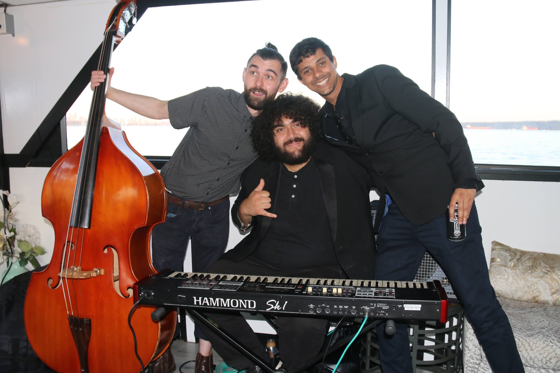 Live jazz trio posing with upright bass and Hammond organ on the boat