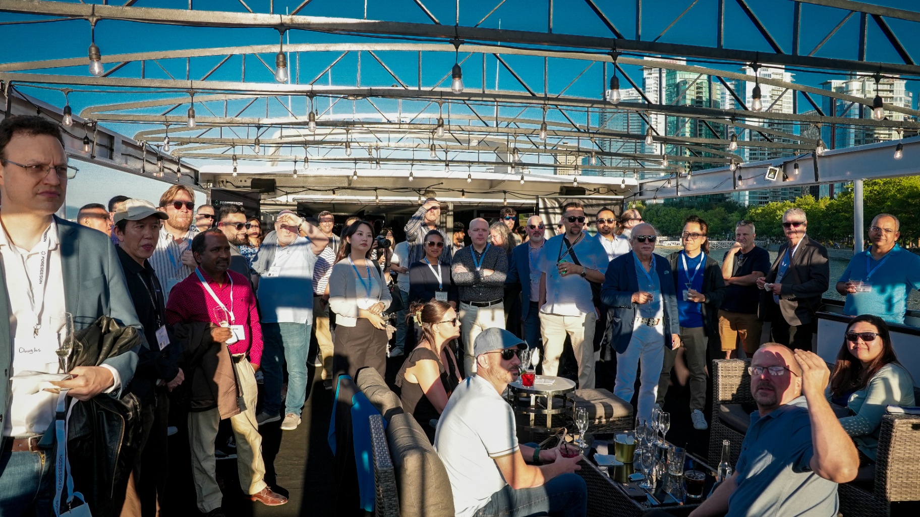 Crowd of guests on the cruise deck with Vancouver skyline behind