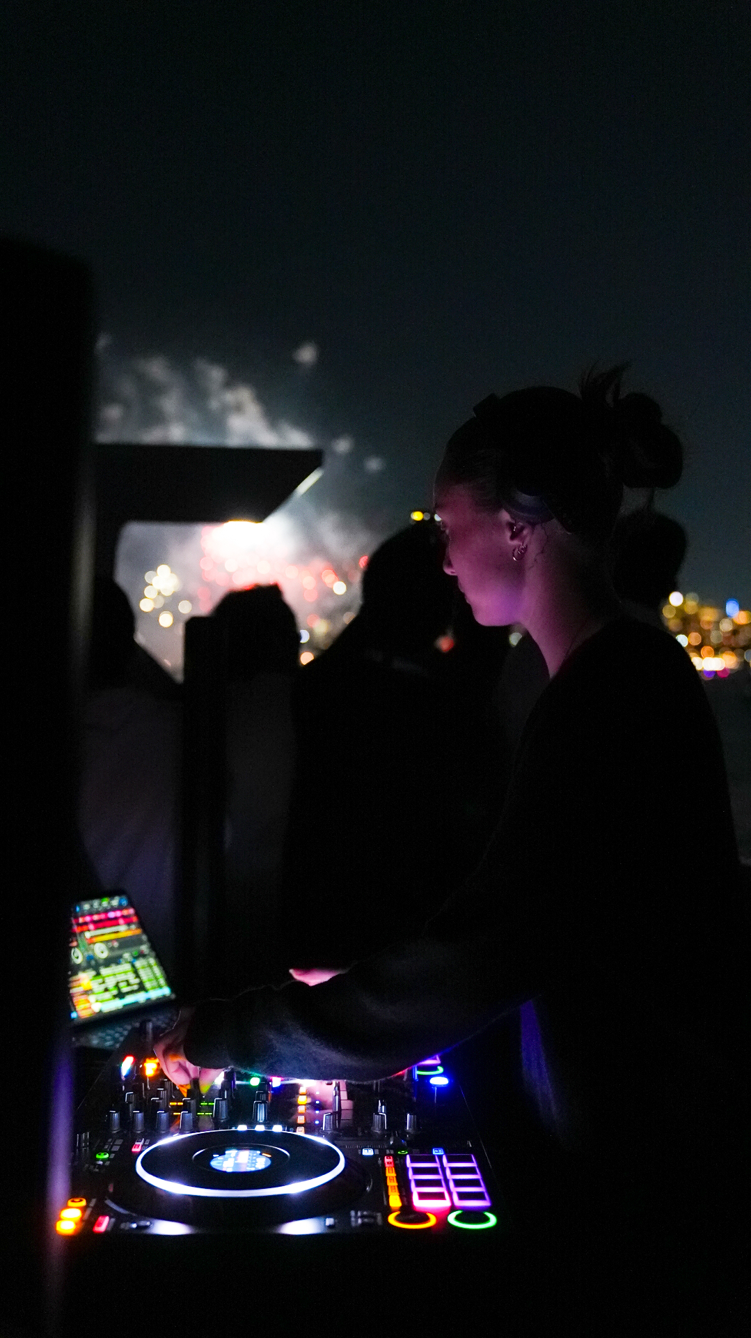 DJ playing under fireworks at night