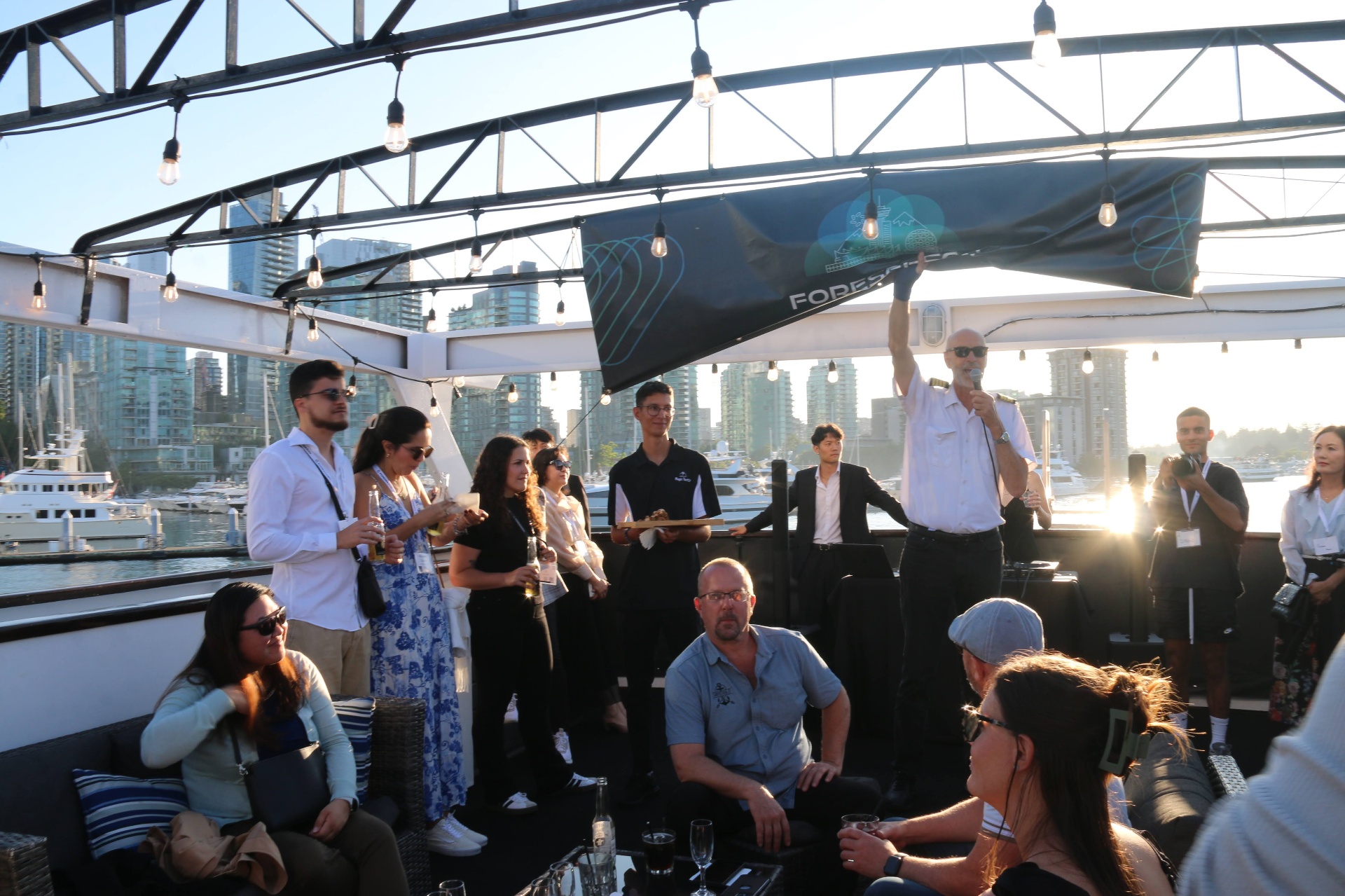 Captain raising a toast with guests on the cruise deck at sunset